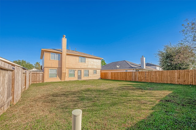 rear view of property featuring a yard