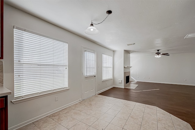 unfurnished living room featuring ceiling fan and light hardwood / wood-style floors