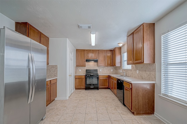 kitchen with tasteful backsplash, exhaust hood, sink, black appliances, and light tile patterned flooring