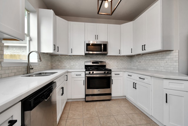 kitchen featuring appliances with stainless steel finishes, decorative backsplash, white cabinetry, and sink