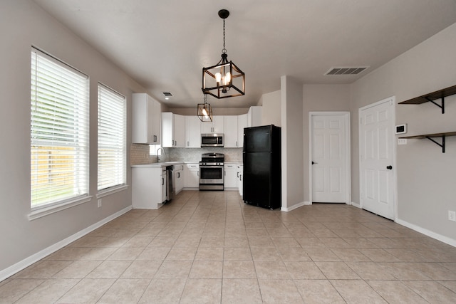 kitchen featuring light tile patterned flooring, pendant lighting, white cabinetry, appliances with stainless steel finishes, and tasteful backsplash