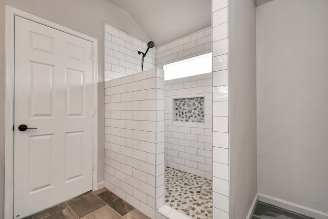 bathroom featuring a tile shower and lofted ceiling