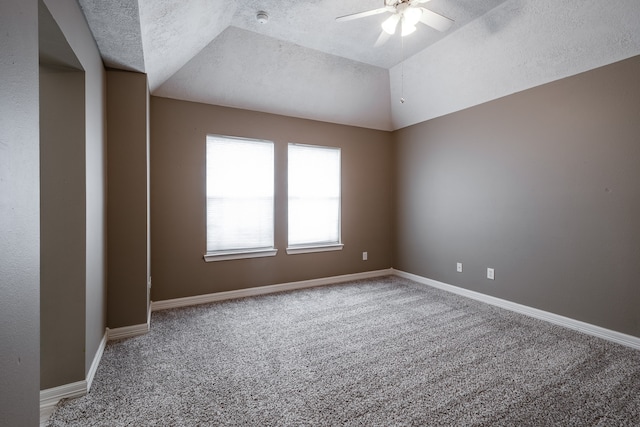 carpeted spare room featuring vaulted ceiling, ceiling fan, and a textured ceiling