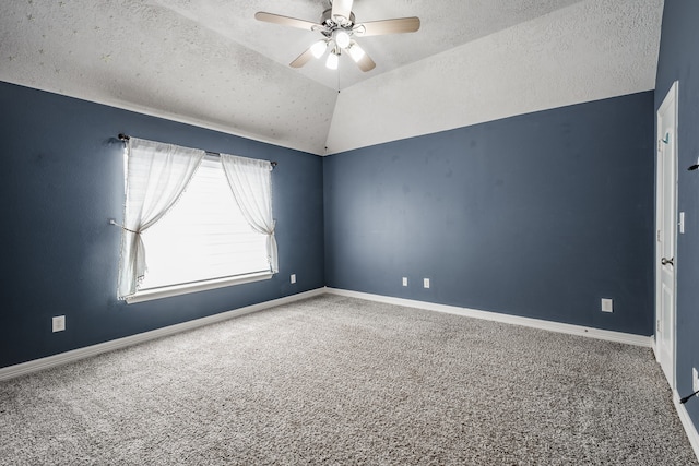 carpeted empty room with a textured ceiling, vaulted ceiling, and ceiling fan