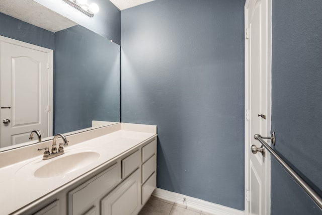 bathroom with tile patterned flooring, vanity, and a textured ceiling