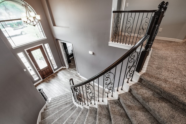 entrance foyer featuring a chandelier, a towering ceiling, and hardwood / wood-style flooring