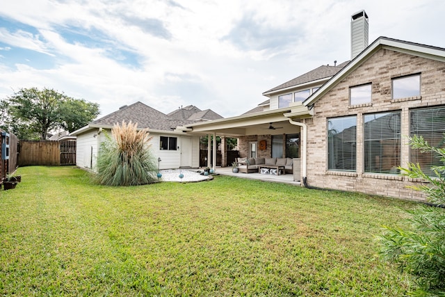 rear view of house with a yard, an outdoor hangout area, a patio, and ceiling fan