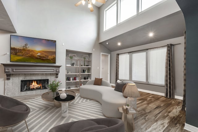 living room featuring hardwood / wood-style floors, high vaulted ceiling, and ceiling fan