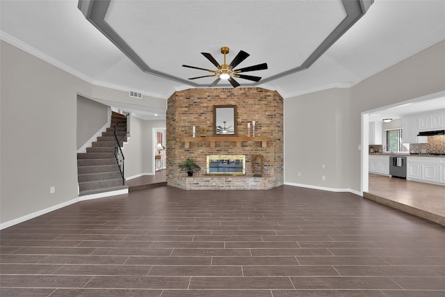 unfurnished living room featuring crown molding, dark wood-type flooring, and ceiling fan