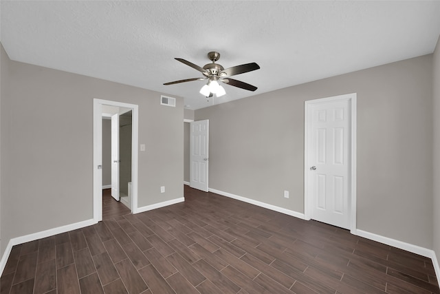 unfurnished bedroom with dark hardwood / wood-style floors, a textured ceiling, and ceiling fan