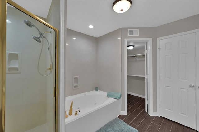 bathroom with shower with separate bathtub and wood-type flooring