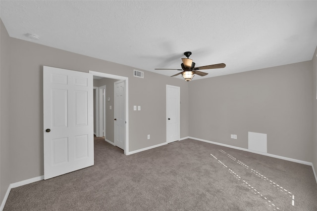 carpeted spare room featuring a textured ceiling and ceiling fan