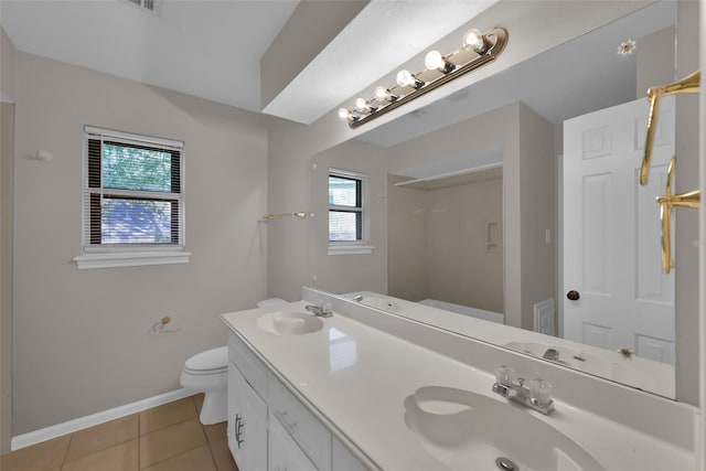 bathroom featuring vanity, toilet, a wealth of natural light, and tile patterned flooring