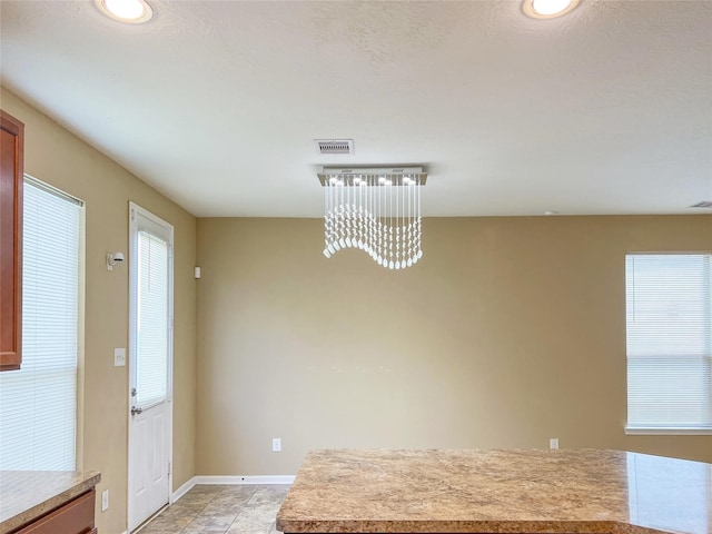 unfurnished dining area featuring a chandelier and light tile patterned floors