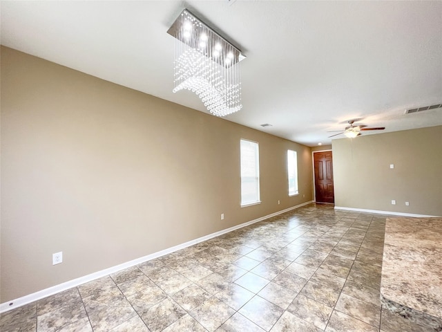 unfurnished room with ceiling fan with notable chandelier