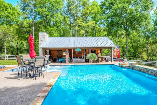 view of pool featuring an outdoor structure, a patio, and pool water feature