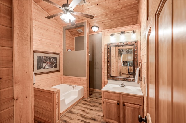 bathroom featuring hardwood / wood-style floors, a tub to relax in, wooden walls, and vaulted ceiling