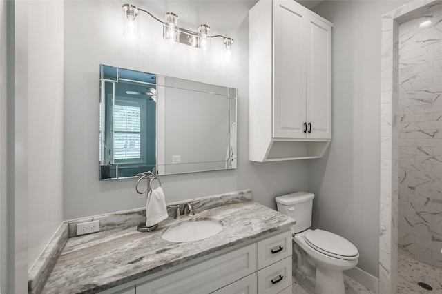 bathroom featuring toilet, vanity, and a tile shower