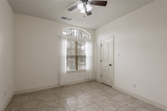 tiled spare room featuring ceiling fan