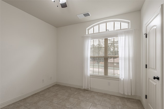 tiled empty room featuring a healthy amount of sunlight and ceiling fan