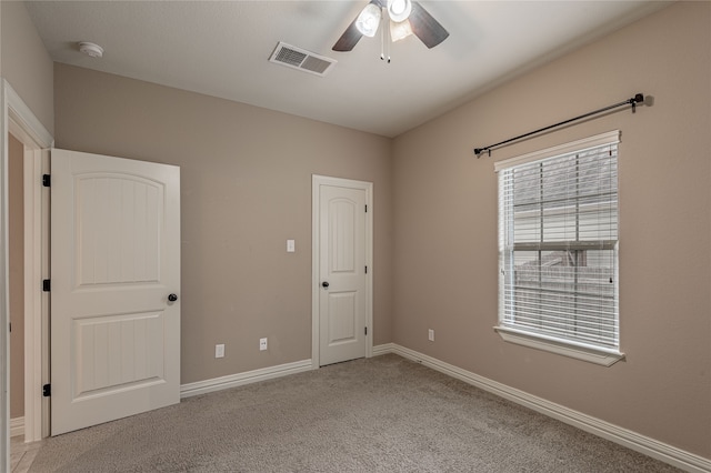 unfurnished bedroom with ceiling fan and light colored carpet