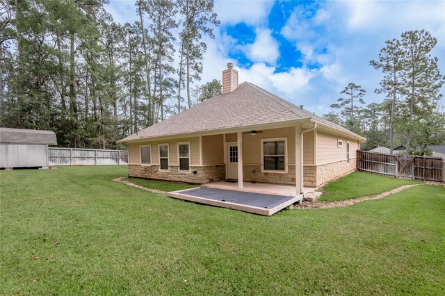 rear view of property featuring a storage unit, a wooden deck, and a yard