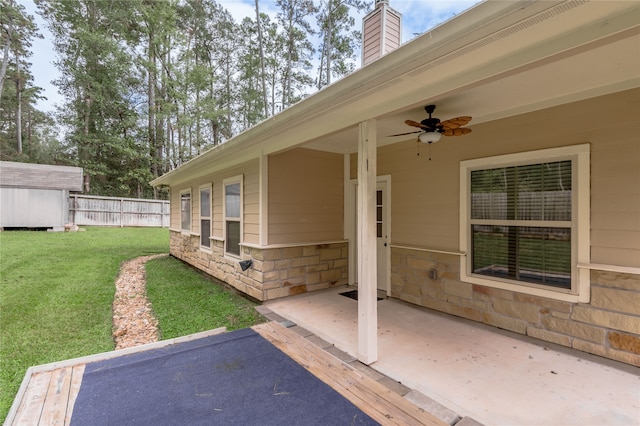 view of patio with ceiling fan and a storage shed