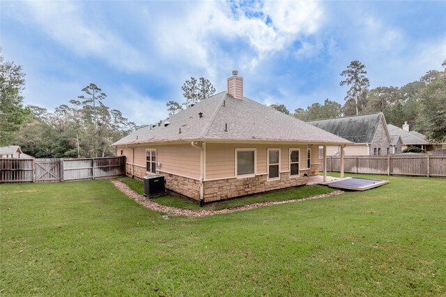 back of property with central AC, a yard, and a patio area