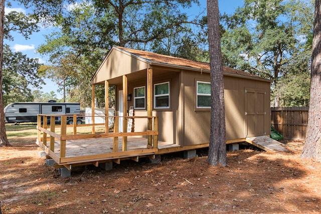 back of property featuring a storage shed and a deck