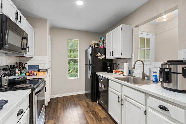 kitchen featuring dark wood-type flooring, backsplash, sink, black appliances, and white cabinetry