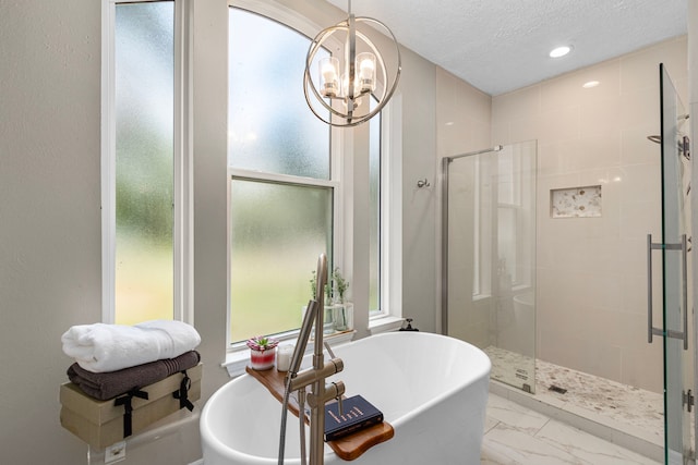 bathroom with an inviting chandelier, a textured ceiling, and plus walk in shower