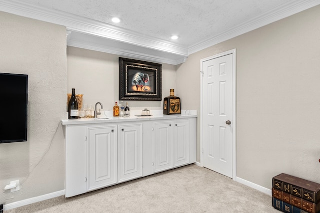 bar with light carpet, crown molding, white cabinetry, and sink