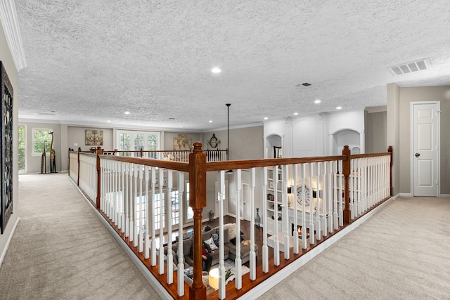 corridor featuring a textured ceiling and light colored carpet