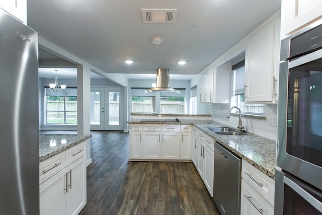 kitchen with appliances with stainless steel finishes, white cabinets, a healthy amount of sunlight, and sink