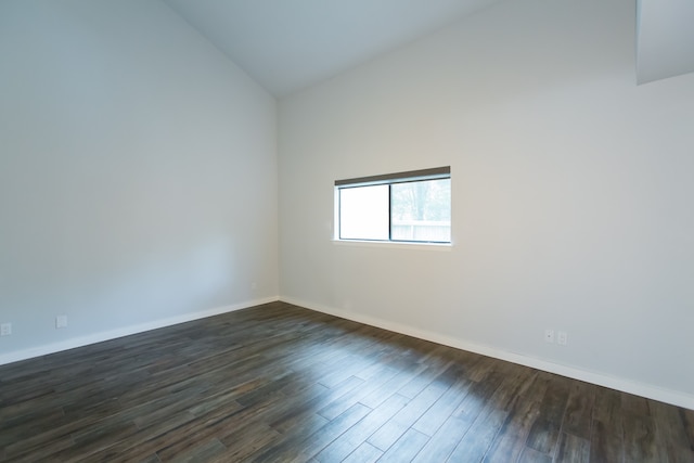 empty room featuring dark wood-type flooring and high vaulted ceiling