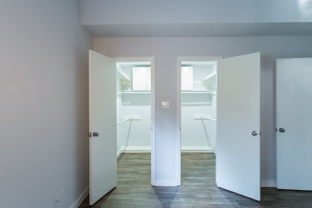 unfurnished bedroom featuring a spacious closet, hardwood / wood-style flooring, and a closet