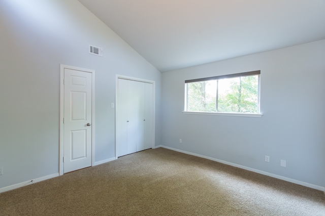 unfurnished bedroom with high vaulted ceiling and carpet