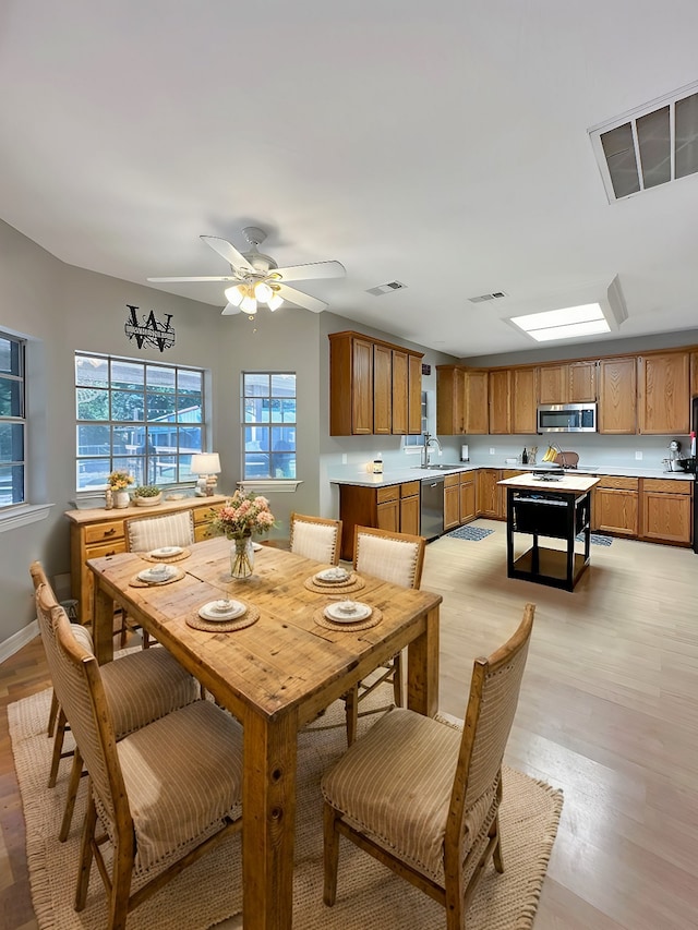 dining room featuring light hardwood / wood-style floors, ceiling fan, and sink