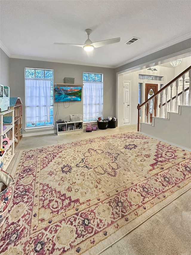 interior space featuring crown molding, ceiling fan, and a textured ceiling