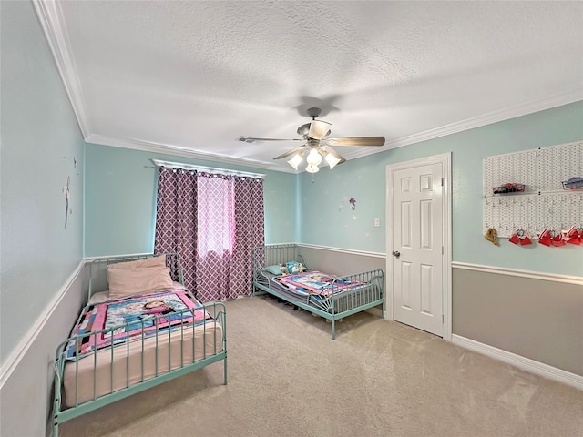 bedroom featuring carpet, ceiling fan, ornamental molding, and a textured ceiling