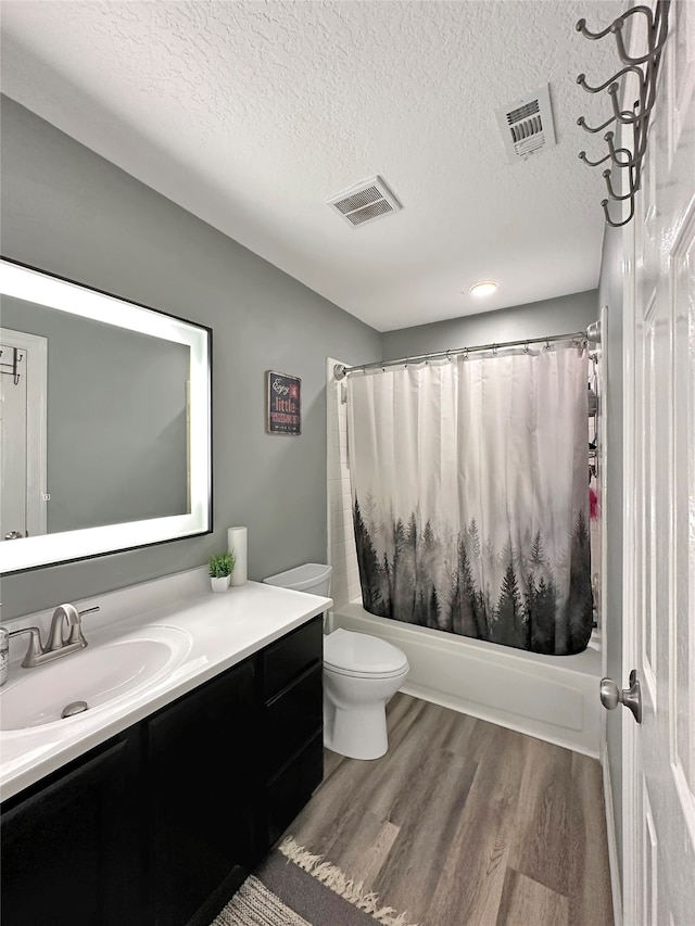 full bathroom featuring hardwood / wood-style floors, shower / bath combo, a textured ceiling, and vanity