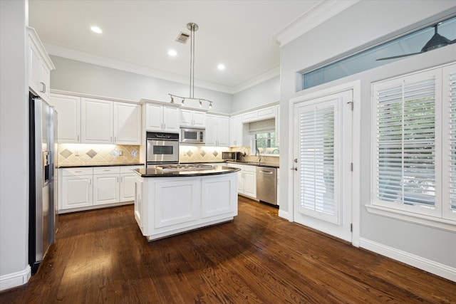 kitchen featuring stainless steel appliances, hanging light fixtures, white cabinets, and dark hardwood / wood-style floors