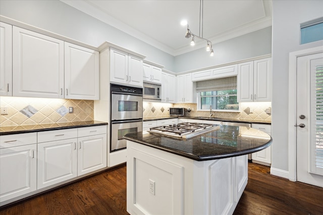 kitchen with white cabinets, stainless steel appliances, dark hardwood / wood-style floors, and a kitchen island