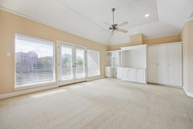 unfurnished living room with ceiling fan, crown molding, light carpet, and french doors