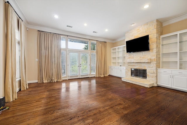 unfurnished living room featuring a stone fireplace, french doors, dark hardwood / wood-style flooring, and crown molding