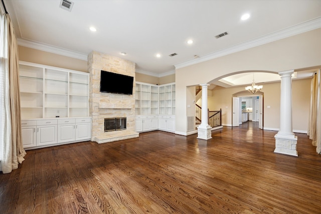 unfurnished living room with a stone fireplace, built in features, wood-type flooring, and ornamental molding