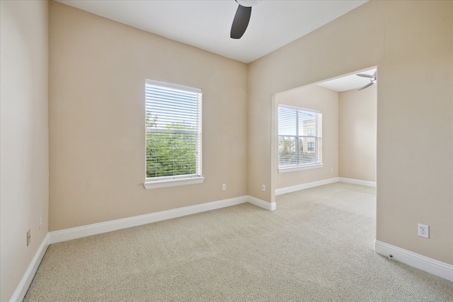 unfurnished room featuring light carpet, ceiling fan, and plenty of natural light