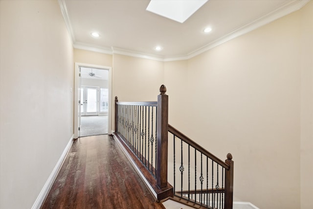 hallway featuring wood-type flooring, a skylight, and crown molding