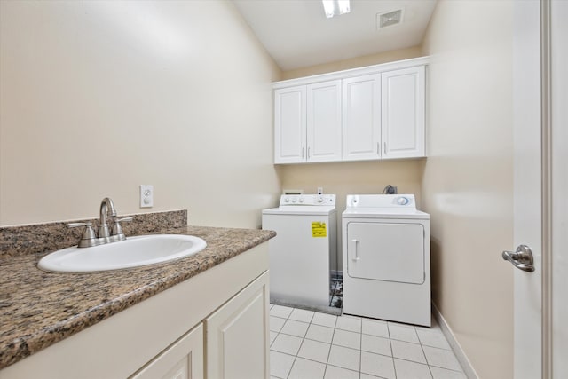 clothes washing area featuring cabinets, washer and clothes dryer, sink, and light tile patterned floors