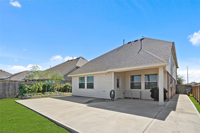 back of house with a patio area and a yard